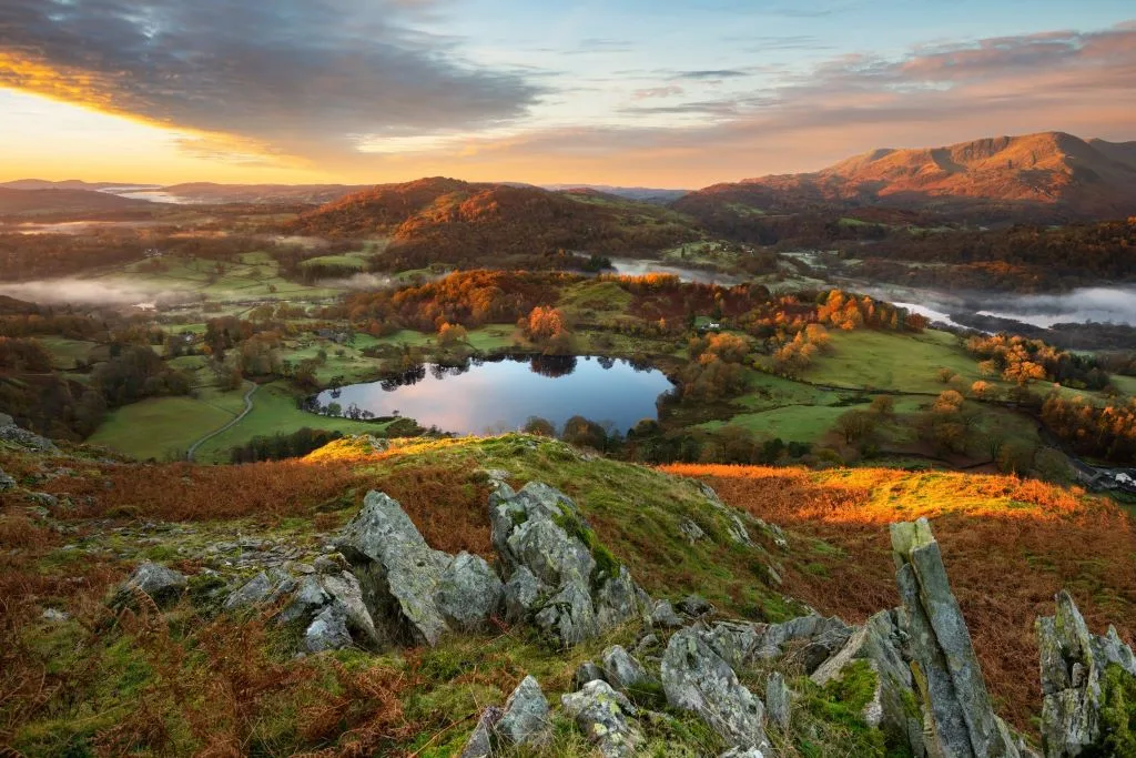 Beautiful Autumn Sunrise Looking Towards View of Lake District Mountain Range Seen From Loughrigg Fell. jpg